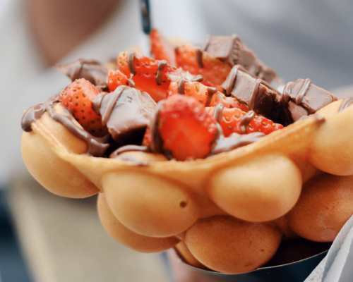 Hand holding a puffle cone with strawberries